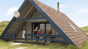 Eine dreieckige Holzhütte mit großem Fenster und Satellitenschüssel.