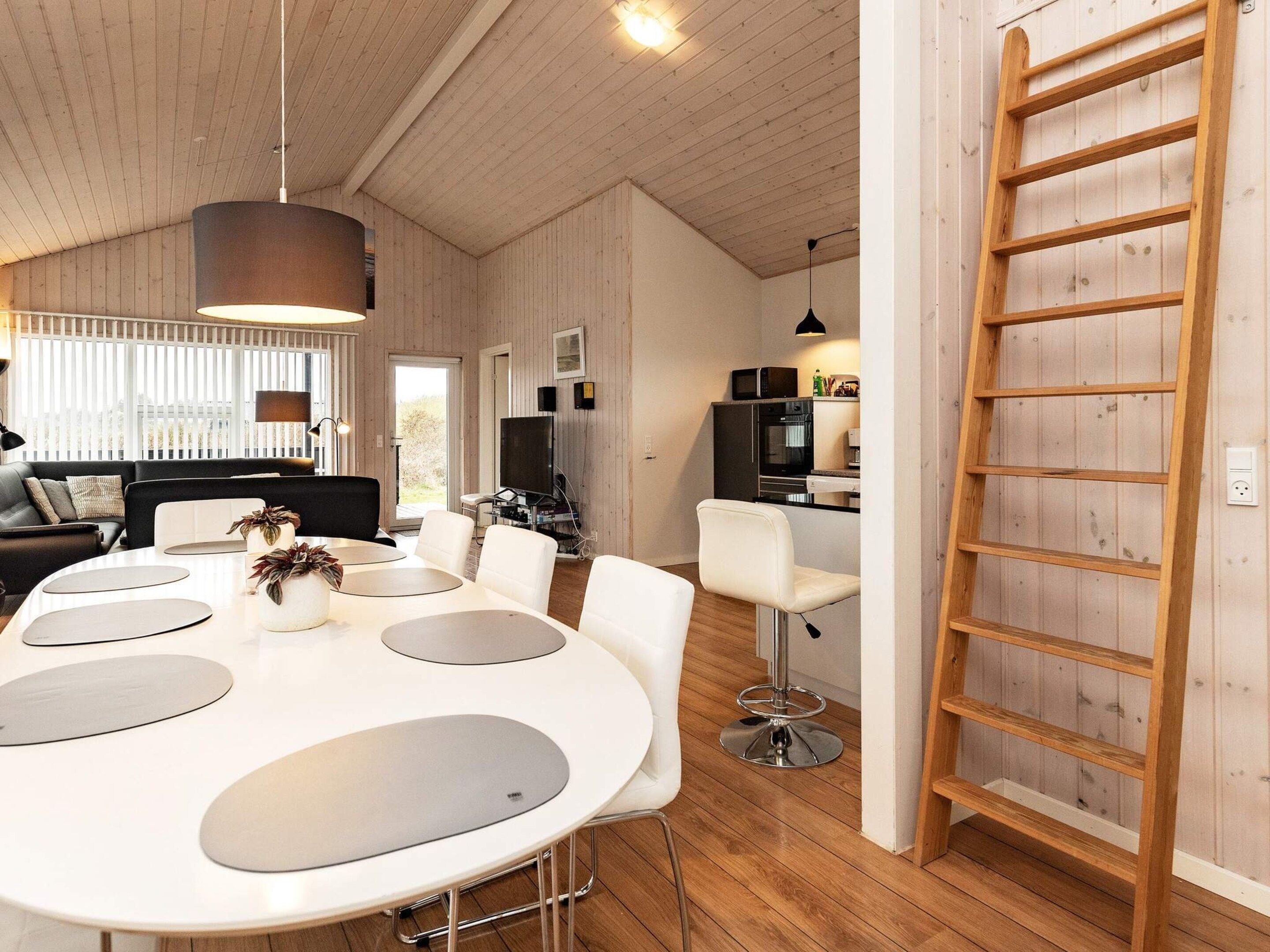 Un intérieur moderne comprenant un espace repas, une cuisine et un espace en mezzanine.