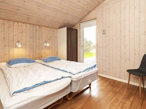 A room with two beds, wooden flooring, and a window with a view. - 4 Star Holiday Home in Hirtshals (Hirtshals)