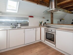 A modern kitchen with white cabinetry, a stainless steel range hood, and a wooden ceiling. - 6 Person Holiday Home in Skjern (Skjern)