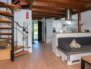 Un intérieur moderne avec un escalier en bois, un canapé et un coin cuisine.