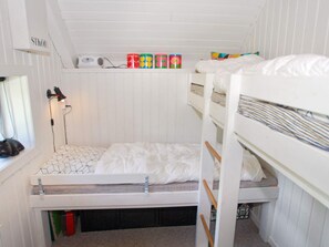 A bunk bed room with a window, a desk with a lamp, and storage boxes. - 6 Person Holiday Home in Skjern (Skjern)