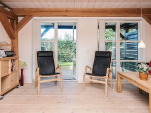 A room with two wooden chairs, a wooden table, and a bookshelf. - 4 Star Holiday Home in Blavand (Blavand)