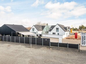 A modern building with a restaurant named 'RESTAURANT PIZZA HOUSE' and a black structure to the left. - 4 Star Holiday Home in Blavand (Blavand)