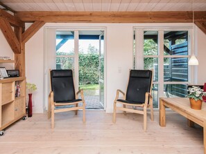 A room with two wooden chairs, a wooden table, and a bookshelf. - 4 Star Holiday Home in Blavand (Blavand)