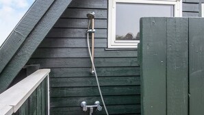 A showerhead attached to a dark wooden wall with a window above it. - 6 Person Holiday Home in Aabenraa-by Traum (Aabenraa)