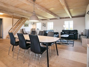 A spacious living area with a dining table, chairs, a sofa, and a TV. - Contemporary Apartment in Faaborg near Sea (Faaborg)