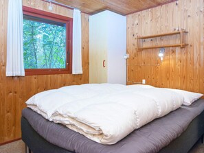 A wooden-paneled room with a bed, a window with curtains, and a wall-mounted shelf. - Spacious Holiday Home In Struer near Ocean (Struer)