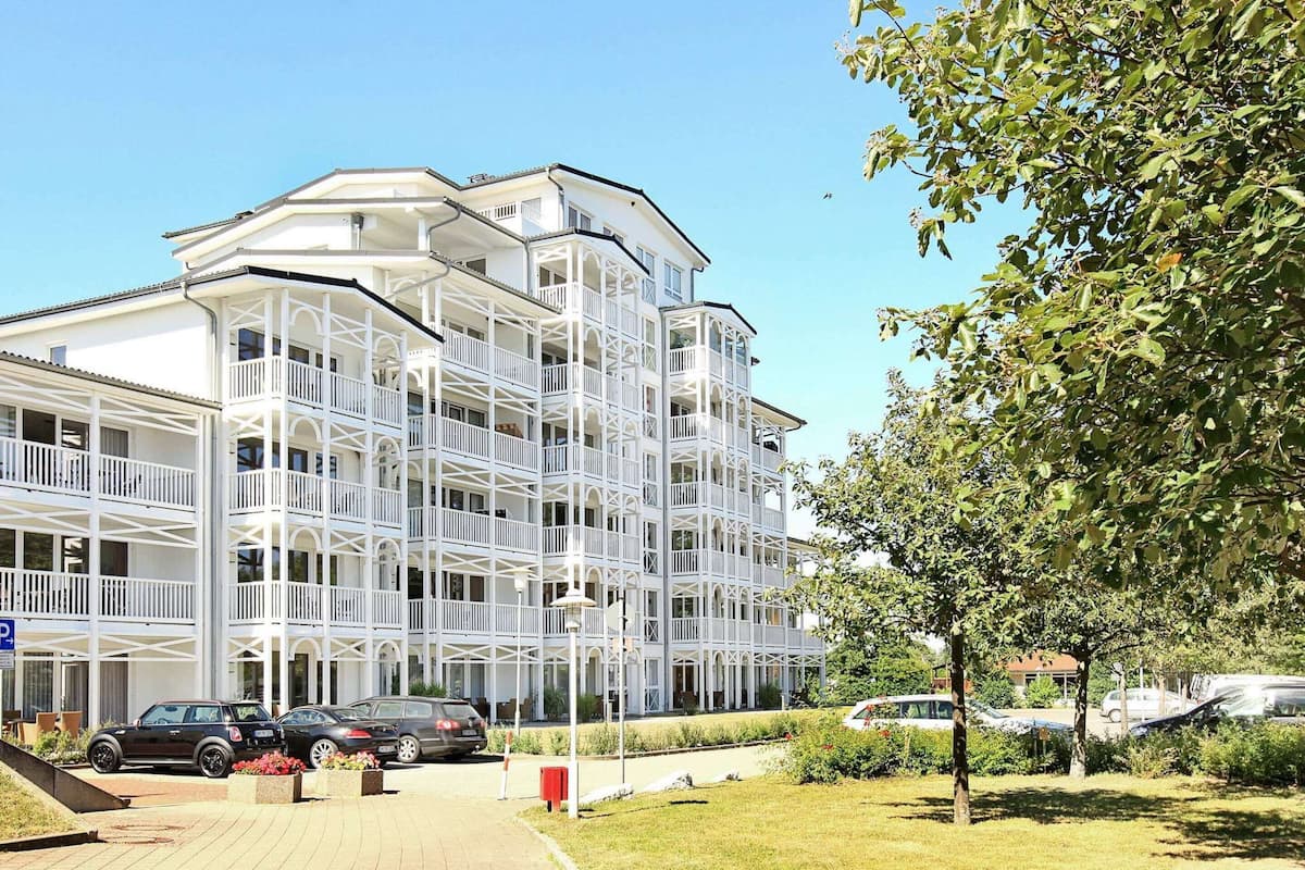 Un hôtel à plusieurs étages, doté de balcons et d’un espace de stationnement.