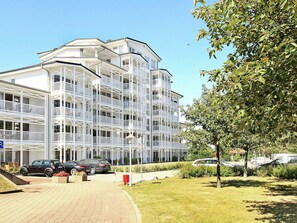 Un hôtel à plusieurs étages, doté de balcons et d’un espace de stationnement.