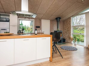 Una cocina moderna con una isla grande, estufa integrada y vistas al exterior.