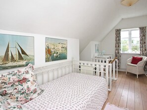 A bedroom with a bed, a chair, a window with curtains, and two paintings on the wall. - 5 Person Holiday Home in Skagen-by Traum (Skagen)