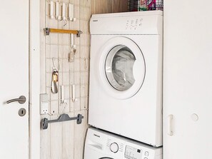 A white washing machine with a Samsung label, a wooden door with a towel rack, and a door handle.