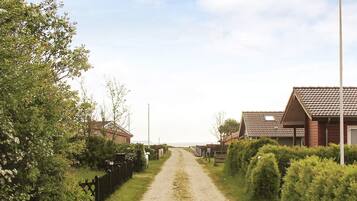 Un camino rural que lleva a casas bajo un cielo despejado.