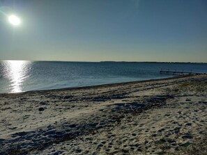 A beach with a clear sky, calm water, and a pier extending into the water. - 6 Person Holiday Home in Assens (Assens)