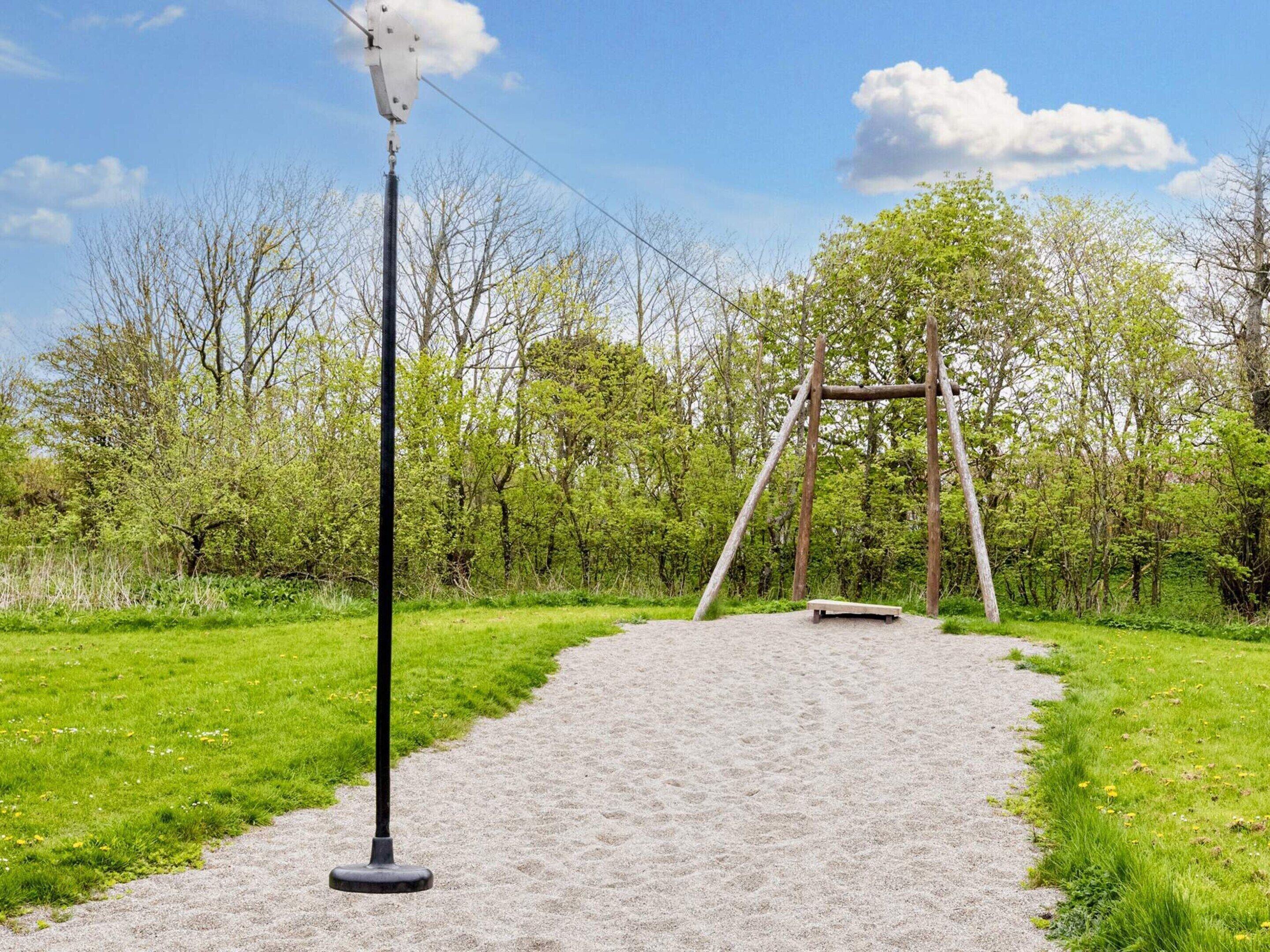 Un sendero de grava que conduce a un columpio en un parque.