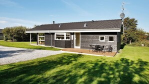 A two-story house with a covered porch, a satellite dish, and a well-maintained lawn. - 5 Star Holiday Home in Vestervig (Vestervig)