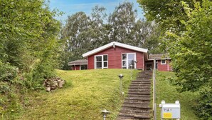 Una casa roja con un porche y una escalera de piedra que lleva a la entrada.