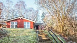 A red building with a staircase leading up to a porch. - 8 Person Holiday Home in Borkop (Borkop)