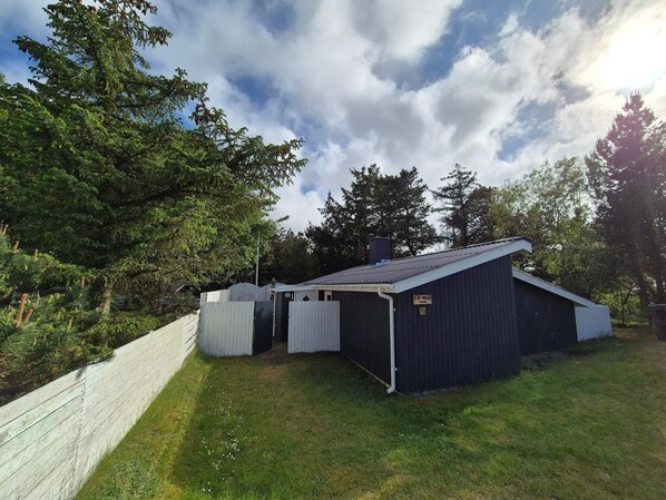 A small, dark-colored shed with a white door and a sign indicating it is number 18.