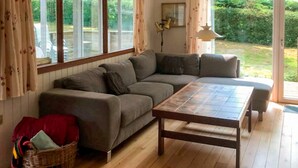 A cozy living room with a sofa, a wooden table, and a wicker basket. - 5 Person Holiday Home in Odder-by Traum (Odder)