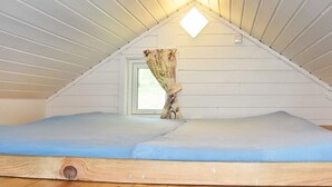 A small attic bedroom with a sloped ceiling, a single window, and a wooden floor. - 4 Person Holiday Home in Folkestad (Volda)