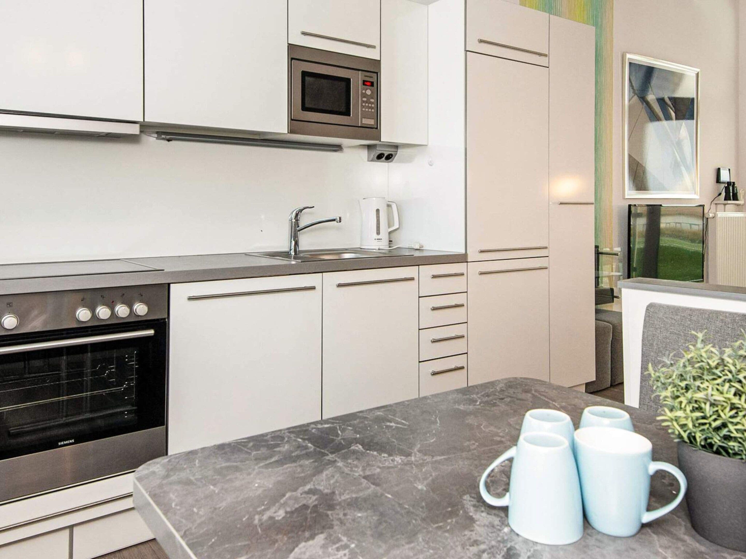 A modern kitchen with a built-in oven, microwave, and coffee maker.