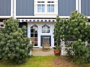 A building with a porch, a bench, and two potted plants. - 4 Star Holiday Home in Blavand (Blavand)