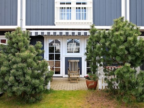 A building with a porch, a bench, and potted plants. - 4 Star Holiday Home in Blavand (Blavand)
