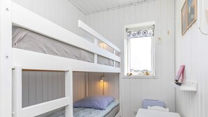 A bunk bed room with a desk and a window.