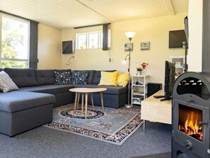 Relax in a cozy living space with a sectional sofa, small table, and stove.