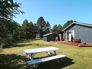 Sit and enjoy the peaceful surroundings at this serene outdoor space with a picnic table and adjacent storage unit.