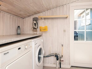 Een wasserette met een wasmachine, een droogrek en een boiler.