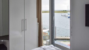 A room with a large window, a wardrobe, and a bed. - Holiday Home in Wendtorf (Schönberg)