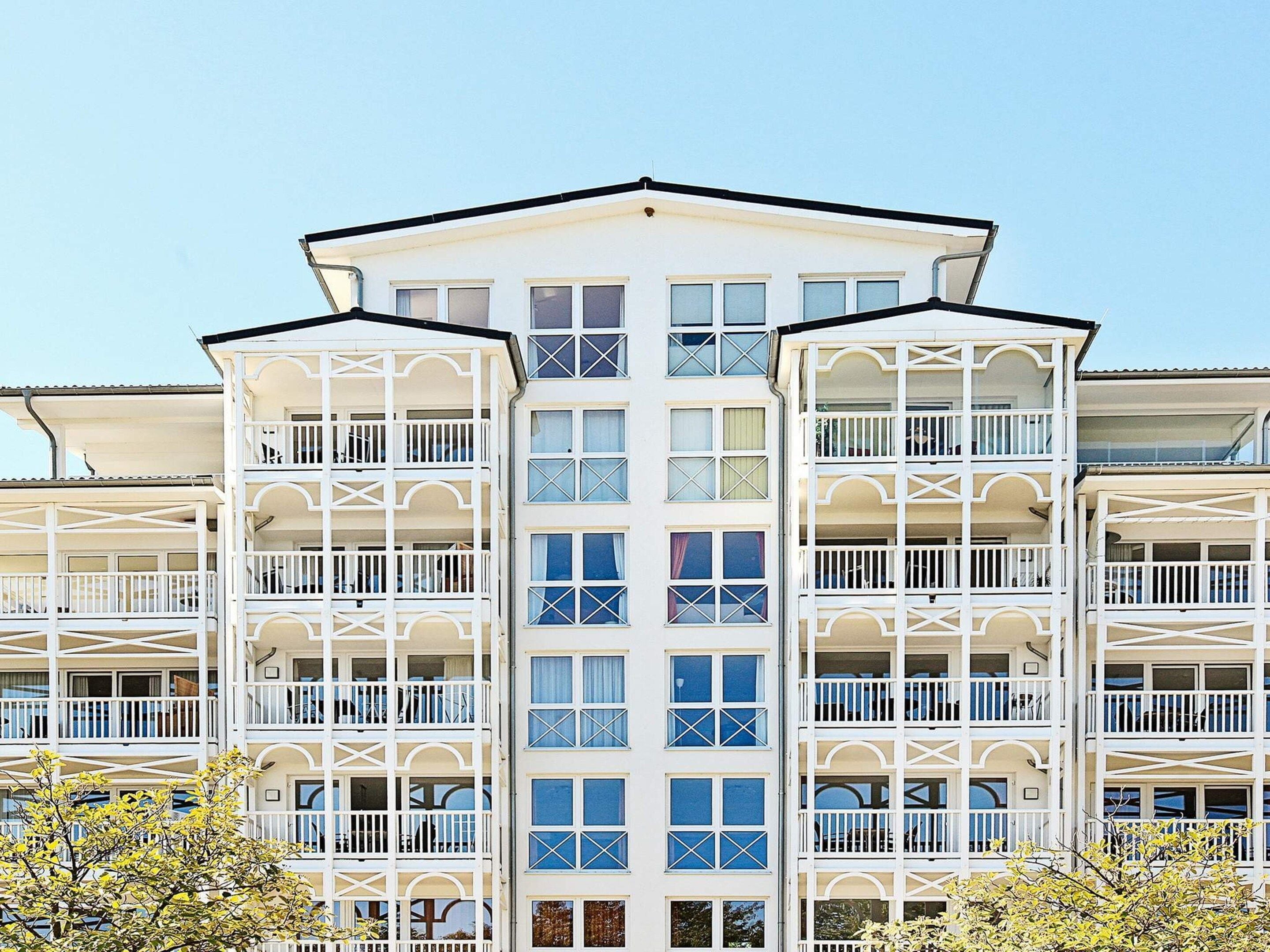 A multi-story hotel with balconies, large windows, and a symmetrical facade.