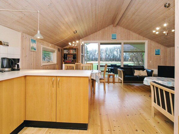 A cozy cabin interior with a kitchen, dining area, and seating space.