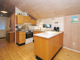 Una cocina compacta con armarios de madera, estufa, microondas y cafetera.