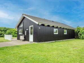 A black building with a sloped roof, a door, and a window. - 4 Star Holiday Home in Harboore (Harboore)