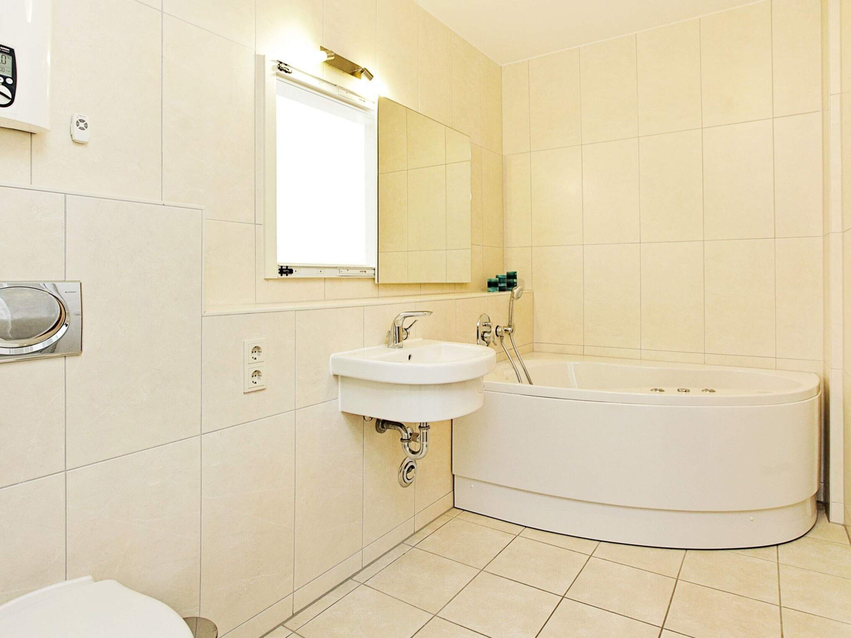 Une salle de bain avec un lavabo, un miroir et une baignoire.