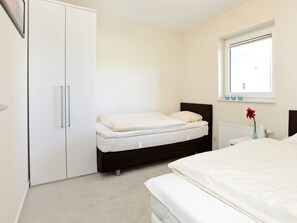 Un dormitorio con una cama, un armario y una ventana.