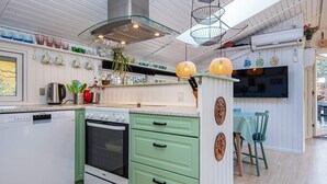 A modern kitchen with white cabinets, green drawers, a Siemens dishwasher, and a vintage stove. - 4 Star Holiday Home in Ansager (Ansager)