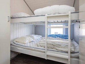 A bunk bed with a ladder, white bedding, and a window with a view. - Spacious Holiday Home in Vestervig near Sea (Vestervig)