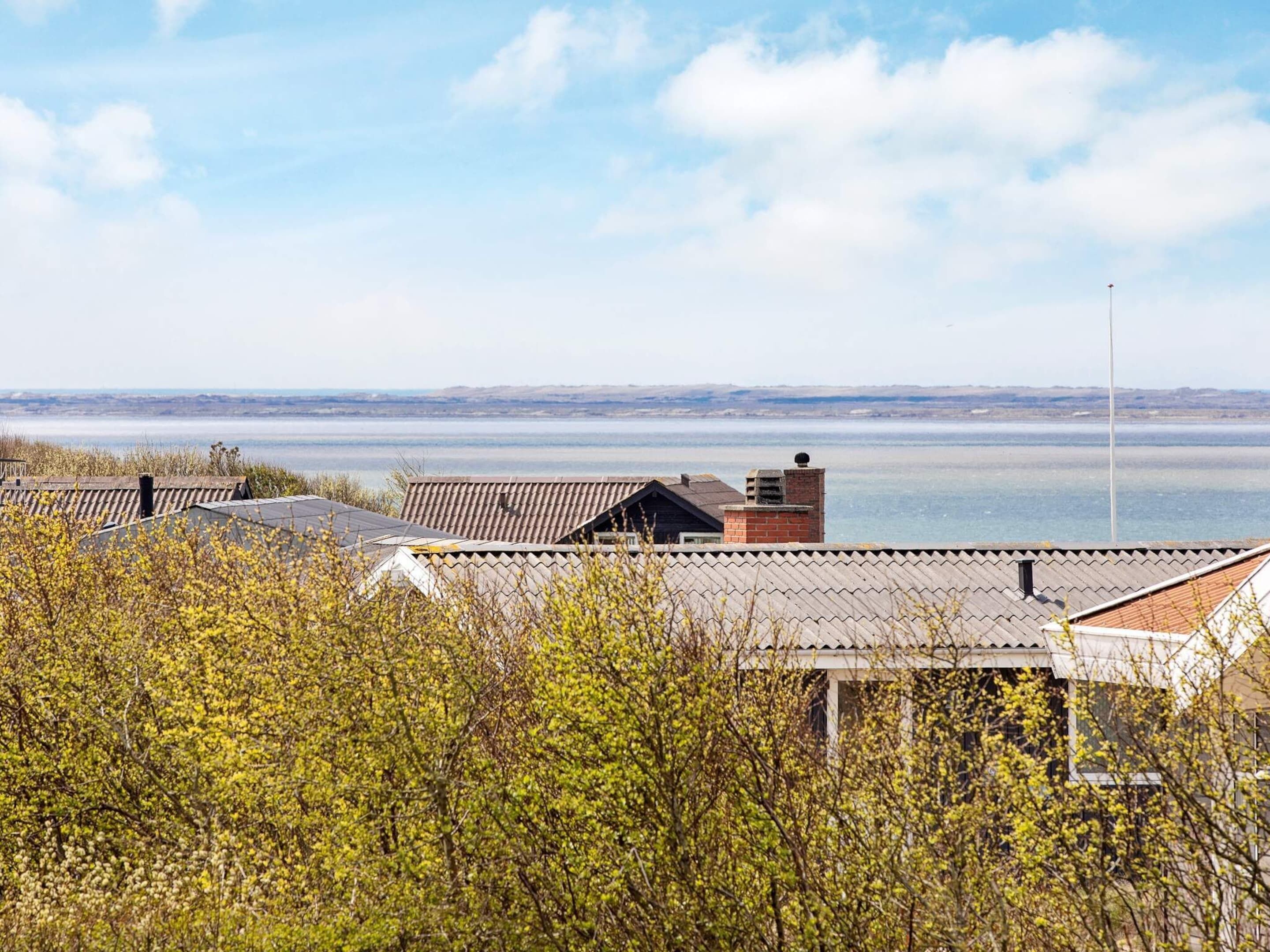 Ein Wohngebiet mit Häusern, blauem Himmel und weiter Wasseransicht.
