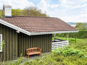 A small, single-story building with a brown tiled roof and a white porch. - 4 Person Holiday Home in Borkop (Borkop)