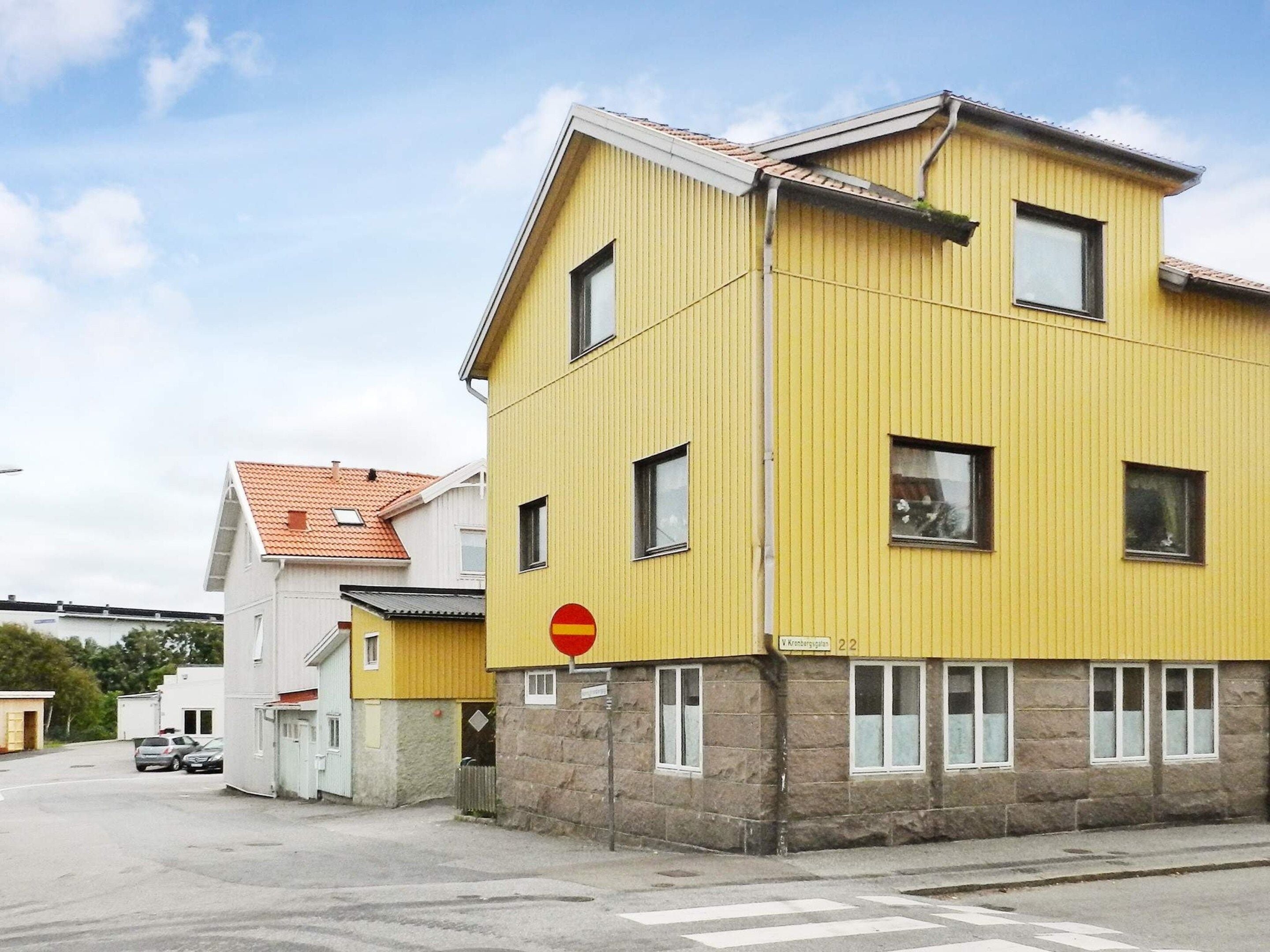 A yellow building with multiple windows and a stop sign.
