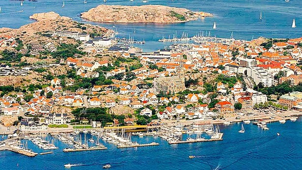 An aerial view of a coastal town with a marina, boats, and buildings with red-tiled roofs. - 3 Person Holiday Home in Lysekil (Lysekil)