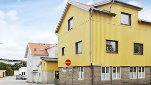 A yellow building with multiple windows and a stop sign. - 3 Person Holiday Home in Lysekil (Lysekil)