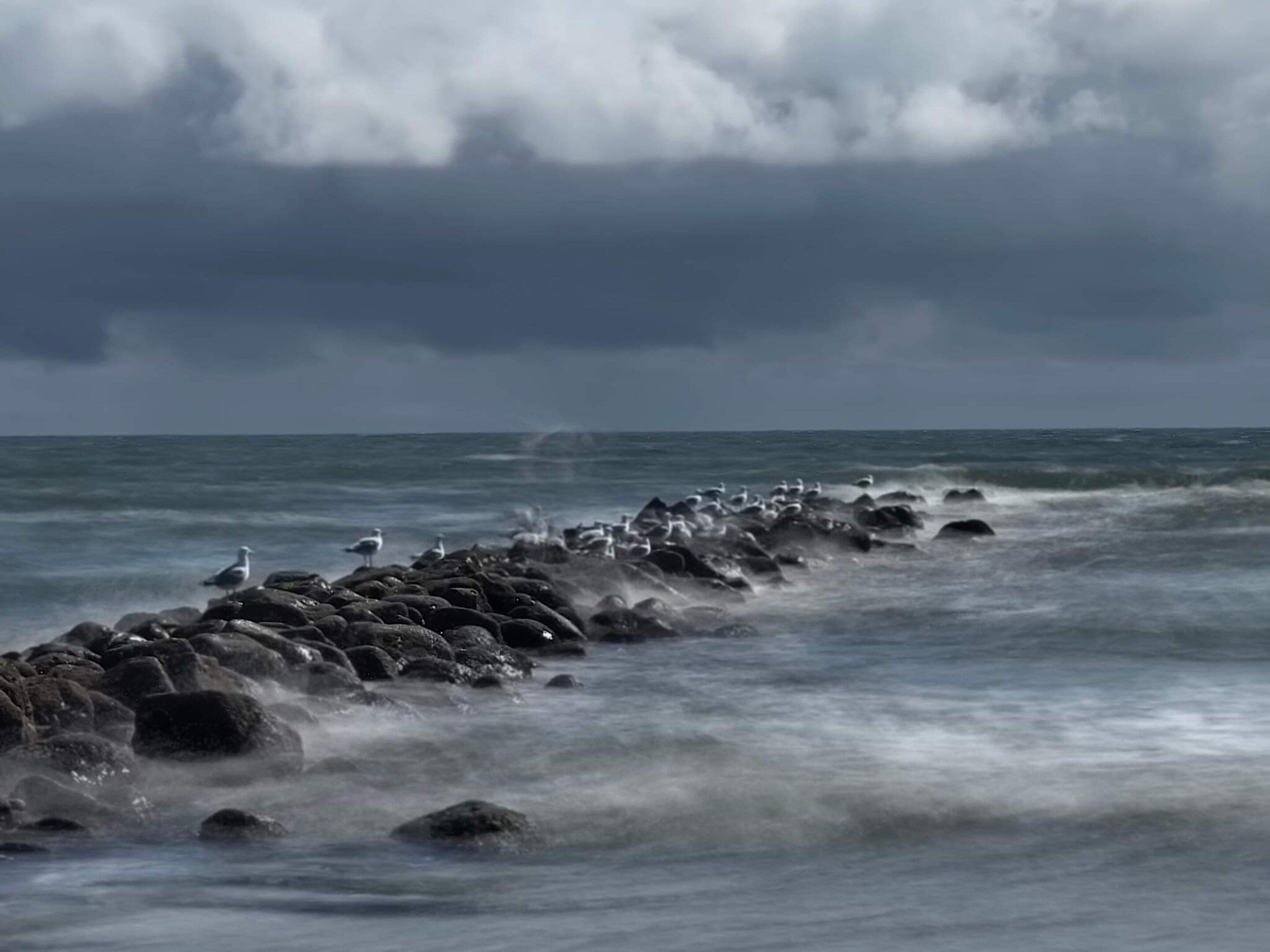 A rocky shoreline with waves crashing against the rocks.