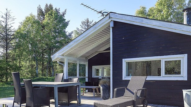 A deck with outdoor furniture, a covered area, and a building with a window. - 5 Person Holiday Home in Albaek (Aalbaek)