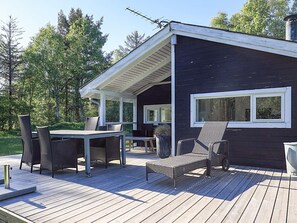 A deck with outdoor furniture, a covered area, and a building with a window. - 5 Person Holiday Home in Albaek (Aalbaek)